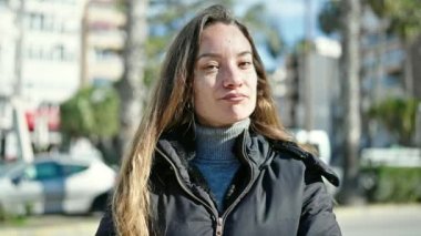 Kafkasyalı genç bir kadın ciddi bir ifadeyle sokakta kafasını sallayarak 