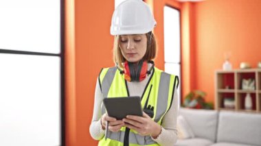 Genç sarışın mimar evde dokunmatik ped kullanarak gülümsüyor.