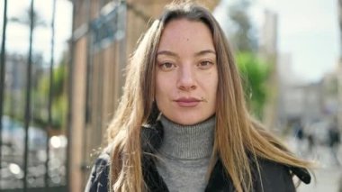 Young caucasian woman standing with serious expression at street