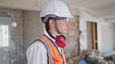 Kafkasyalı genç bir mimar inşaat alanında rahat bir ifadeyle ayakta duruyor.