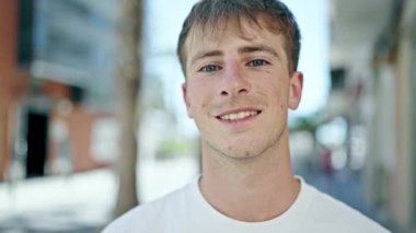 Young caucasian man smiling confident standing at street