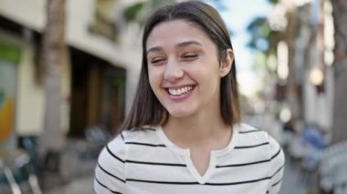 Kahve dükkanının terasında kendine güvenen güzel İspanyol kadın gülümsüyor.