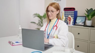 Young blonde woman doctor stressed working at clinic