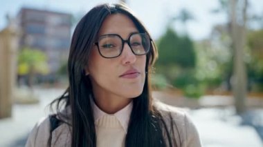 Parkta ciddi bir ifadeyle duran genç, güzel İspanyol kadın.