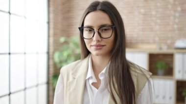 Genç, güzel, İspanyol bir iş adamı. Kendine güler yüzlü. Ofiste kollarını kavuşturmuş duruyor.