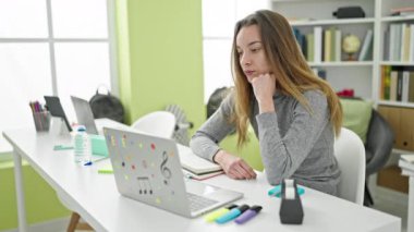 Kütüphane üniversitesinde laptopu kullanan beyaz bir kız öğrenci.