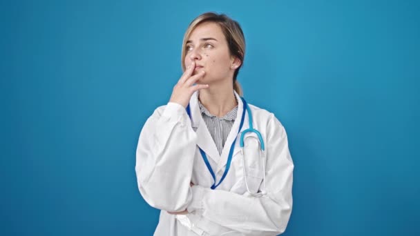 Young Blonde Woman Doctor Standing Doubt Expression Thinking Isolated Blue — Stock Video