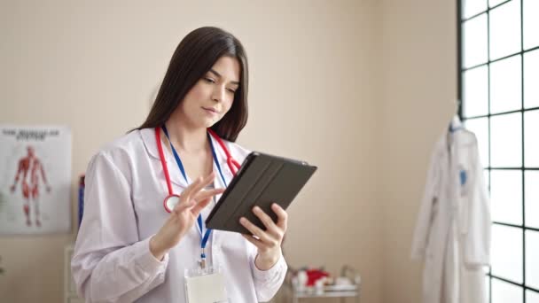 Joven Hermosa Mujer Hispana Doctora Sonriendo Confiada Usando Touchpad Clínica — Vídeo de stock