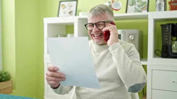 Orta Yaşlı Kır Saçlı Evrak Okuyan Akıllı Telefondan Konuşan Bir — Stok video