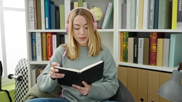 Jovem Loira Estudante Ouvindo Música Leitura Livro Universidade Biblioteca — Vídeo de Stock
