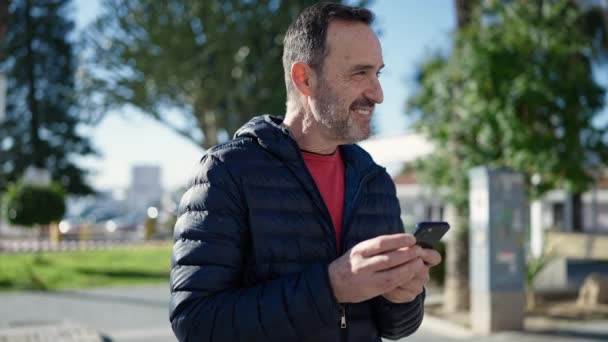 Uomo Mezza Età Sorridente Fiducioso Utilizzando Smartphone Parco — Video Stock
