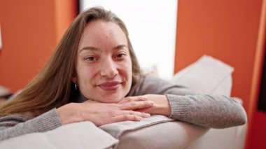 Young caucasian woman smiling confident sitting on sofa at home