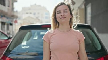 Genç sarışın kadın gülümsüyor. Elinde yeni arabanın anahtarı var.