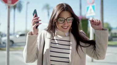 Sokak ortasında müzik dinleyen ve dans eden genç, güzel İspanyol kadın.