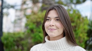 Young beautiful hispanic woman breathing with closed eyes at park