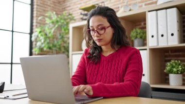 Genç, güzel İspanyol iş kadını. Ofiste laptopunu kazanan ifadesiyle kullanıyor.