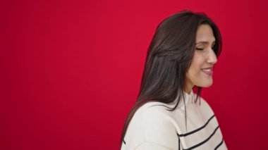 Genç ve güzel İspanyol kadın, kendine güvenen, izole kırmızı arka planda duran.