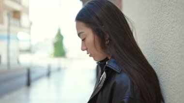 Genç ve güzel İspanyol kadın sokağın karşısında üzgün bir ifadeyle yan tarafa bakıyor.