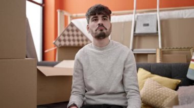 Yeni evin anahtarlarını elinde tutarak gülümseyen İspanyol genç adam.