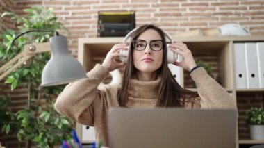 Ofiste dizüstü bilgisayarla dans eden güzel İspanyol iş kadını.