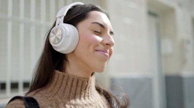 Sokak ortasında müzik dinleyen ve dans eden genç, güzel İspanyol kadın.