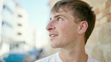 Young caucasian man smiling confident standing at street