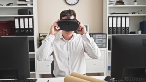 年轻的惊慌失措的建筑师带着虚拟现实眼镜在办公室里微笑 — 图库视频影像