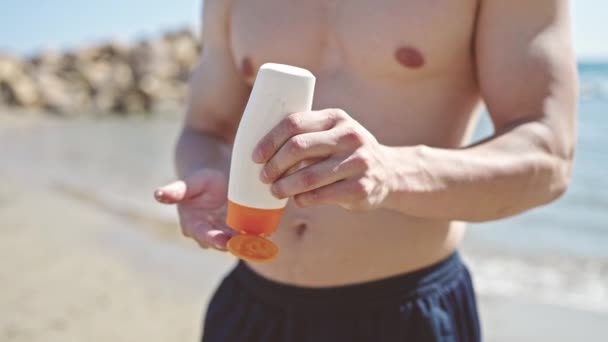 年轻的他的惊慌失措的游客在海滨用防晒霜 — 图库视频影像