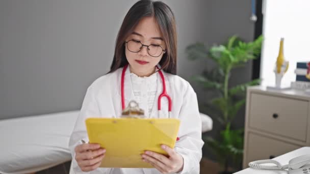 Молодая Китаянка Врач Пишет Медицинское Заключение Клинике — стоковое видео