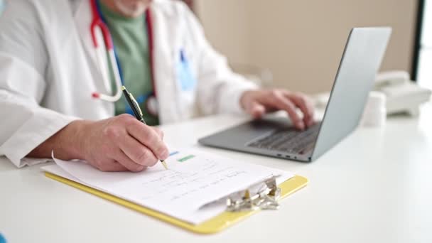 Médico Cabelos Grisalhos Meia Idade Usando Laptop Escrevendo Relatório Médico — Vídeo de Stock