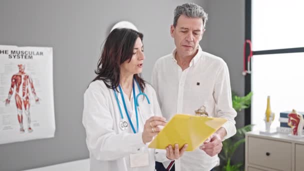 Senior Man Woman Doctor Patient Reading Medical Report Having Consultation — Stock Video