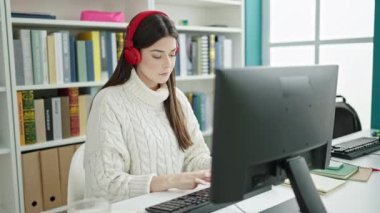 Portakal suyu içen genç, güzel İspanyol kız öğrenci üniversite sınıfında ders çalışıyor.