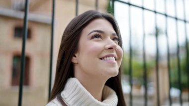 Young beautiful hispanic woman breathing with closed eyes at street