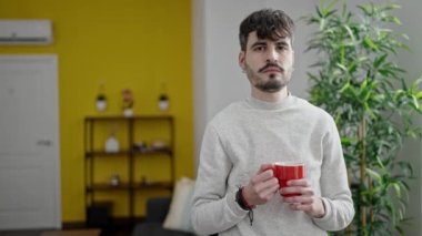 Genç İspanyol adam evde kahve içiyor.
