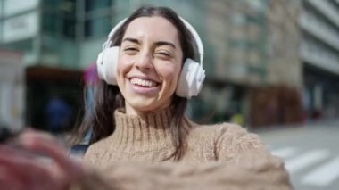 Sokak ortasında müzik dinleyen ve dans eden genç, güzel İspanyol kadın.