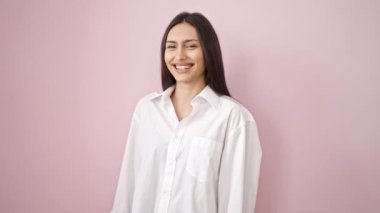 Young beautiful hispanic woman smiling confident standing over isolated pink background