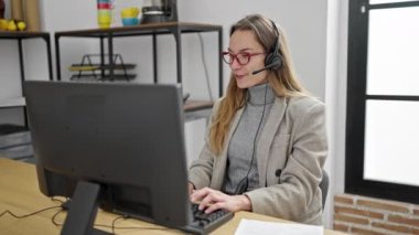 Ofiste çalışırken gülümseyen beyaz kadın çağrı merkezi ajanı.