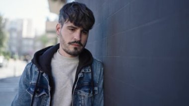 Sokakta ciddi bir ifadeyle duran İspanyol genç adam.