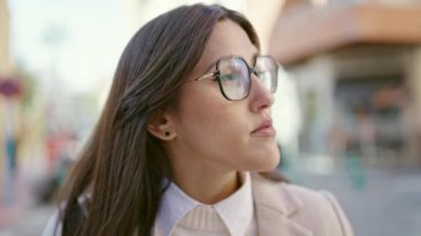 Sokakta ciddi bir ifadeyle duran genç, güzel İspanyol kadın.