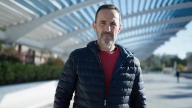 Middle age man doing stop gesture with hand at park