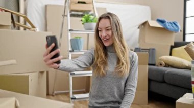 Kafkasyalı genç bir kadın yeni evinde video kaydı tutuyor.