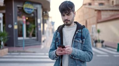 Sokakta akıllı telefon kullanan genç bir İspanyol.