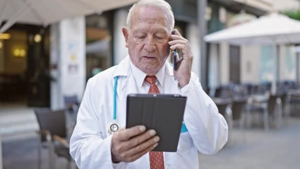 Senior Médico Hombre Pelo Gris Usando Touchpad Hablando Teléfono Inteligente — Vídeo de stock