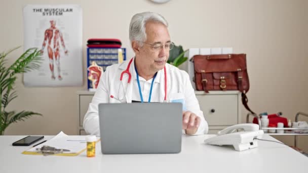 Mann Mittleren Alters Mit Grauen Haaren Arzt Telefoniert Mit Laptop — Stockvideo