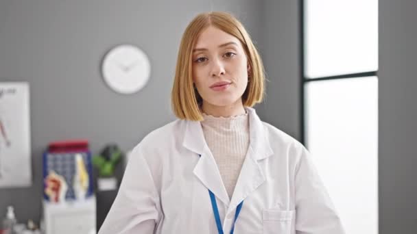 Młoda Blondynka Lekarz Stoi Poważnym Wyrazem Twarzy Noszenie Stetoskop Klinice — Wideo stockowe