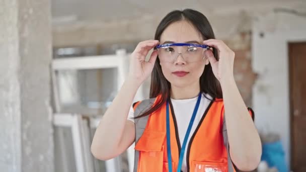 Jovem Chinesa Mulher Construtor Sorrindo Confiante Decolando Óculos Segurança Local — Vídeo de Stock
