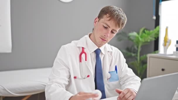 Νεαρός Καυκάσιος Γιατρός Που Χρησιμοποιεί Χάπια Συνταγογράφησης Laptop Στην Κλινική — Αρχείο Βίντεο