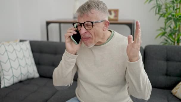 Orta Yaşlı Kır Saçlı Koltukta Oturan Yüzünde Öfkeli Bir Ifadeyle — Stok video