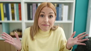 Genç, sarışın bir kız öğrenciyle oturuyor. Üniversite sınıfında nasıl derler bilmiyorum.