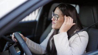 Genç ve güzel İspanyol kadın sokakta esneyerek araba kullanmaktan yoruldu.